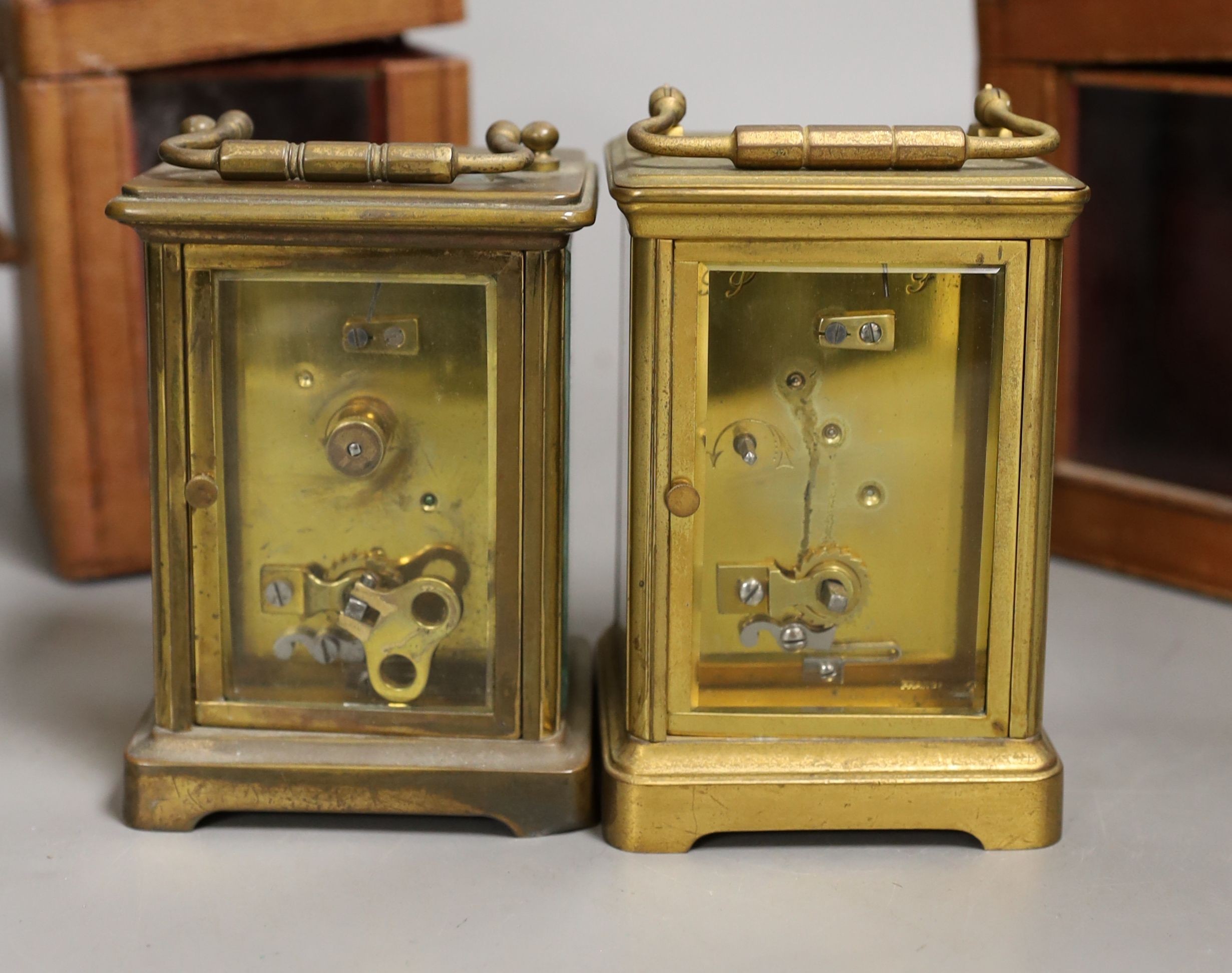 Two leather cased brass carriage timepieces, 14 cms high including case.